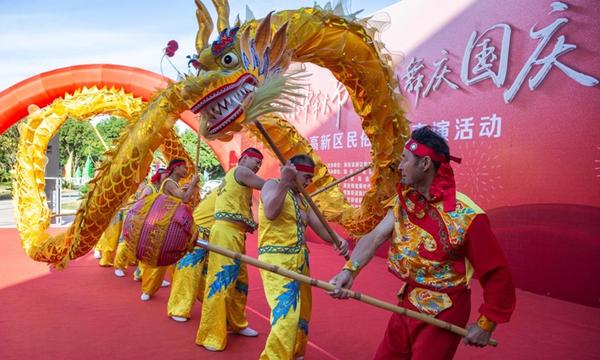 A dragon dance performance is staged at a square in Haian, east China's Jiangsu Province, Oct. 1, 2023. People across the country enjoy themselves in various way on the first day of the National Day holiday. (Photo by Zhai Huiyong/Xinhua)